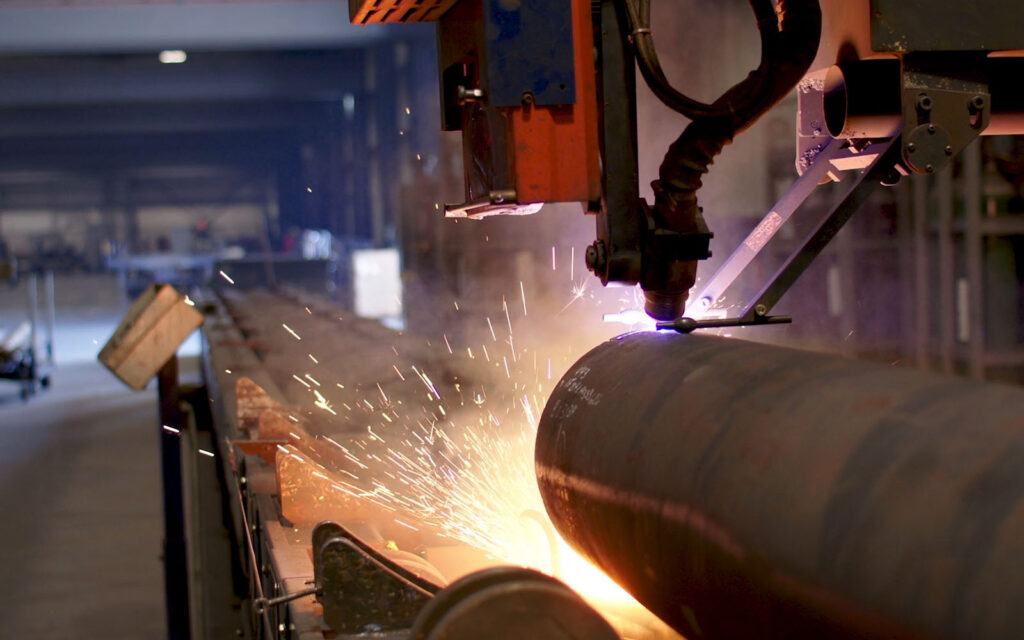 A large pipe being cut and welded.