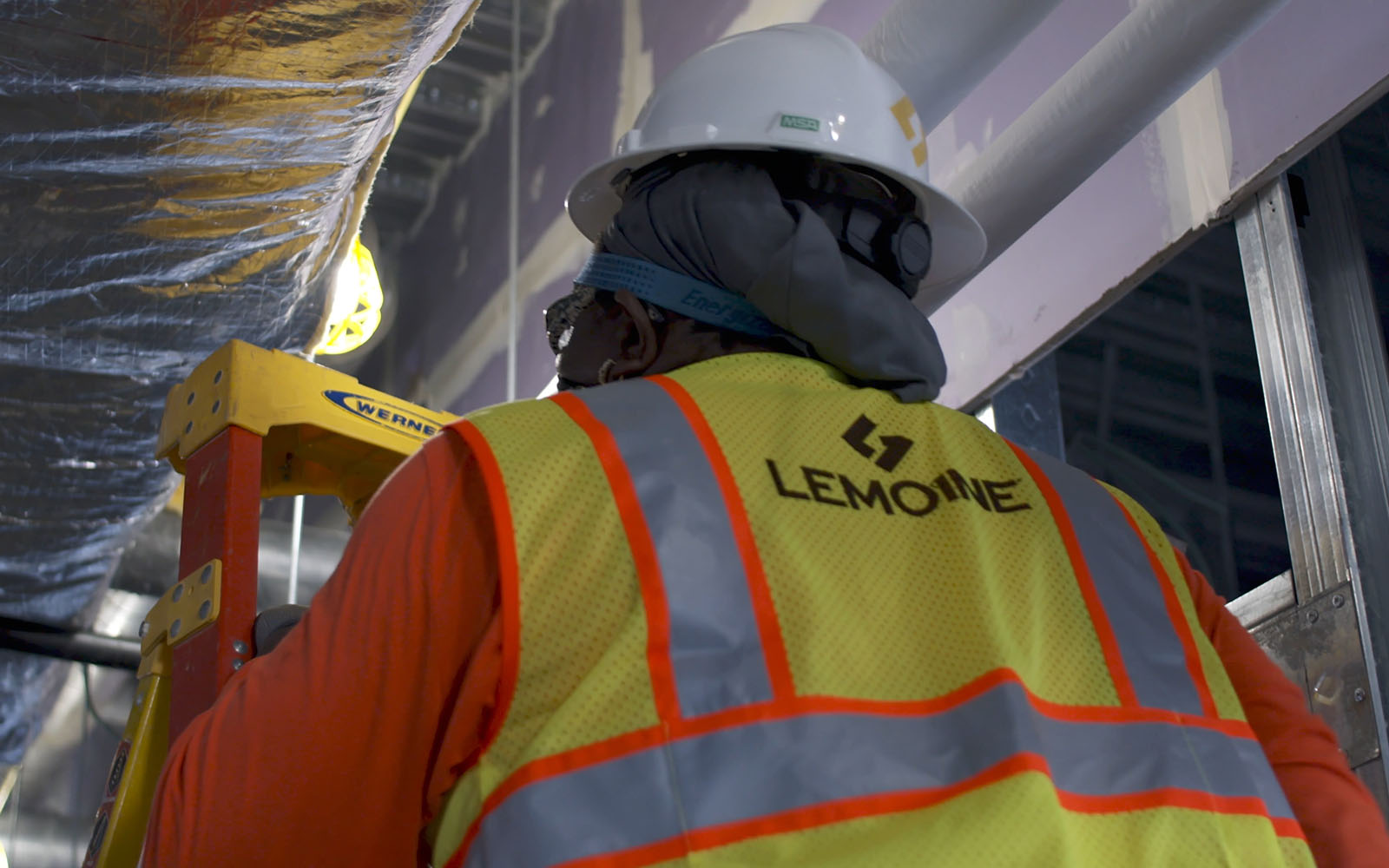 a Lemoine employee climbing up a ladder.