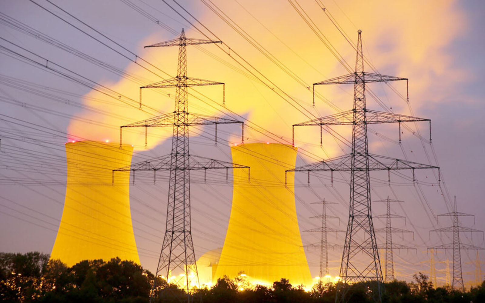 Multiple power lines connected together with 2 nuclear power plant towers in the distance.