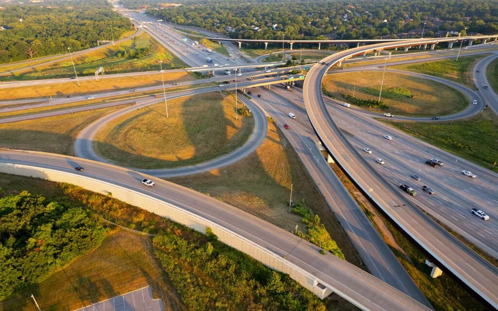 A large interstate system with multiple ramps and vehicles traveling throughout the system.