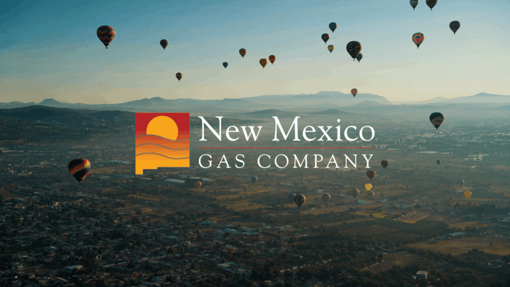 An aerial image of hot air balloons flying over New Mexico overlayed with the New Mexico Gas Company logo.